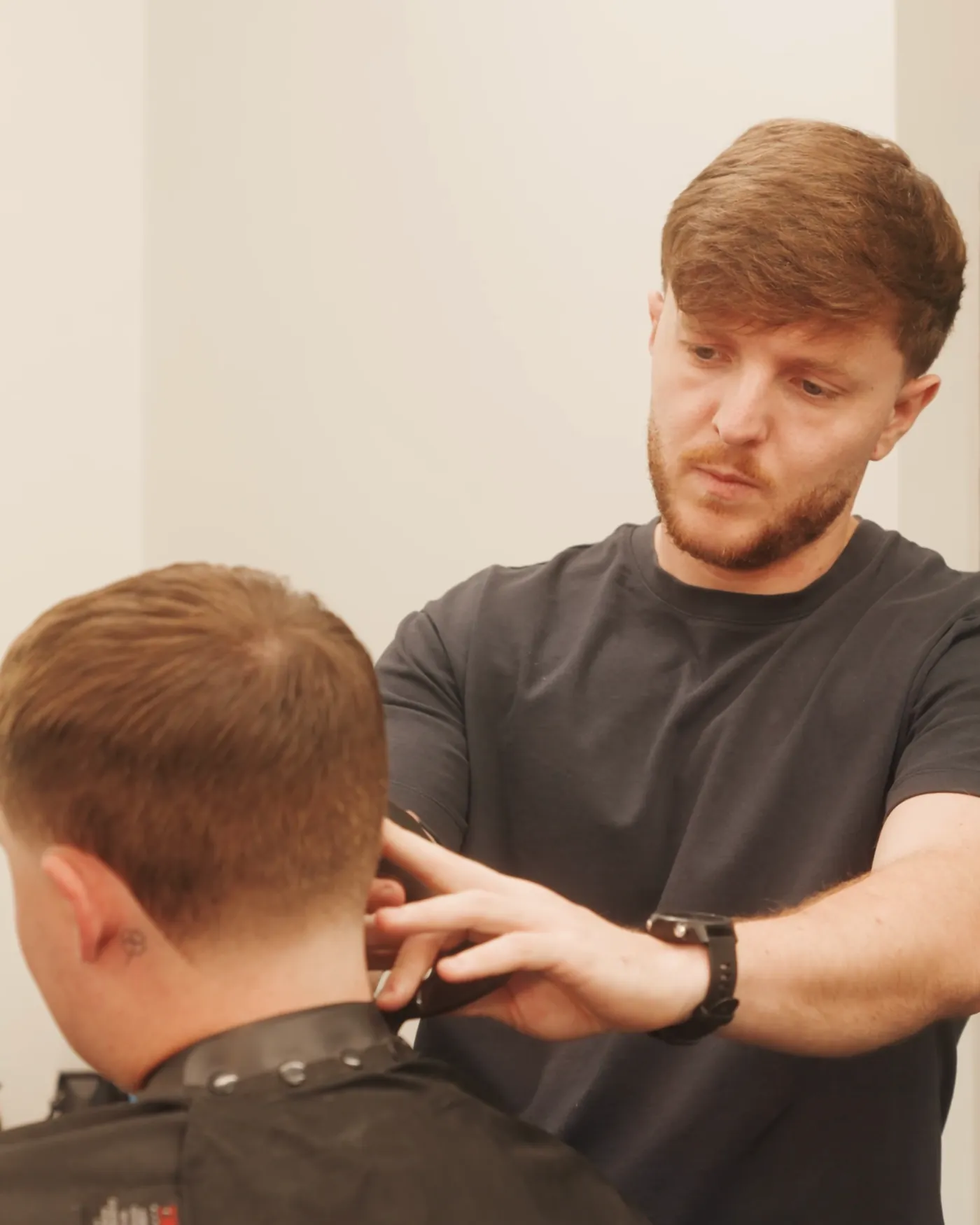 Jack Rember cutting a client's hair at JWR Barbers